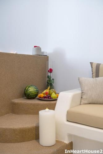 a living room with a couch and a table with a candle at In Heart House - Naousa, Paros in Naousa