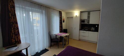 a small room with a small table and a kitchen at Appartements am Schillergarten in Dresden