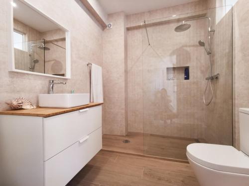 ein Badezimmer mit Dusche, Waschbecken und Toilette in der Unterkunft Lagos Sea View Apartment in Lagos