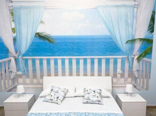 a bedroom with a bed and a view of the ocean at Nammuratè - Casa Vacanze in Naples