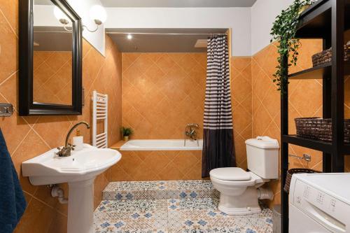 łazienka z toaletą, umywalką i wanną w obiekcie Negroni Apartments w Krakowie
