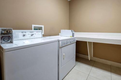 a laundry room with a washing machine and a counter at Comfort Suites Miamisburg - Dayton South in Miamisburg