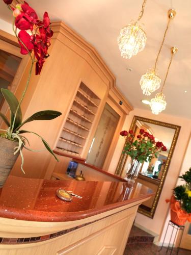a kitchen with a counter with flowers on the wall at Hotel Mondial in Bellaria-Igea Marina