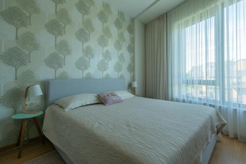 a bedroom with a large bed and a window at 39DO in Druskininkai