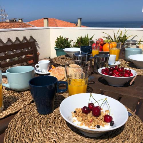 a table with a plate of food and fruit on it at Casas dos Seixos in Moledo