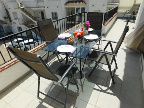 a glass table and chairs on a balcony at GMID IMMO A-223 MOLI DE VENT Atico in Roses