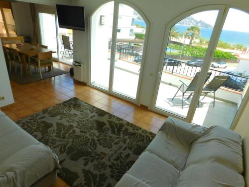 a living room with a couch and a balcony at GMID IMMO A-223 MOLI DE VENT Atico in Roses
