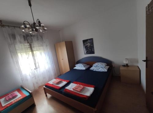 - une petite chambre avec un lit bleu et une fenêtre dans l'établissement Family apartment near beach, à Biograd na Moru