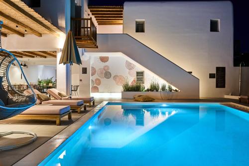 a swimming pool in a living room with a house at Adorno Beach Hotel and Suites in Ornos
