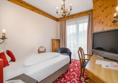 Una televisión o centro de entretenimiento en Hotel Alpina - Thermenhotels Gastein