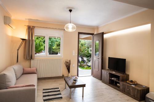 a living room with a couch and a tv at Marathos Apartment in Lefkada