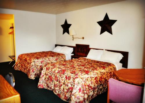 two beds in a hotel room with stars on the wall at Town House Motel in Rapid City
