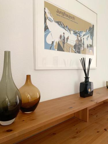 two vases sitting on a wooden table with a picture at Casa Mika in Konstanz