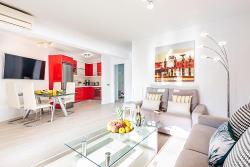 een woonkamer met een bank en een tafel bij Tenerife South Apartments in Playa de las Americas