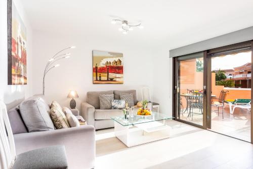 a living room with a couch and a table at Tenerife South Apartments in Playa de las Americas