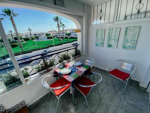 - Balcón con mesa y sillas y vistas a un campo de golf en Stunning 2 bedroom apartment with Pool View, en Alicante