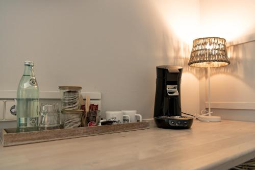 a table with a coffee maker and a lamp on it at Ko´Ono Hotel in Konstanz