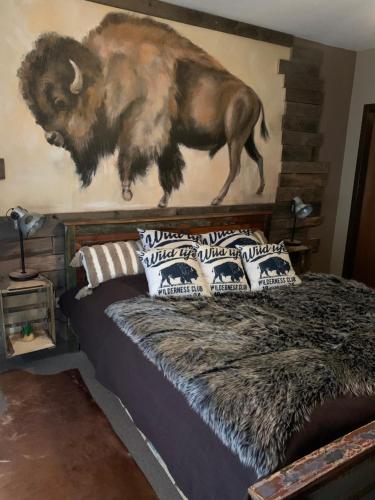 a bedroom with a painting of a buffalo on the wall at Longhorn Ranch Countryhotel - Garni in Schönau