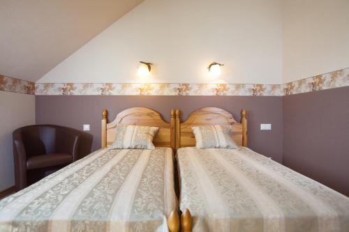 a bedroom with two beds and a chair at Liepas in Ventspils