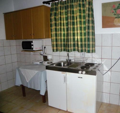 a small kitchen with a sink and a table at Mirabelle Hotel in Argassi