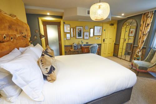 a bedroom with a large white bed and a chair at The Kings Arms in London