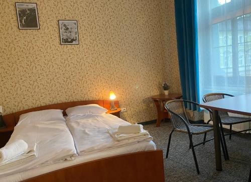 a bed in a room with a table and chairs at Hotel i Restauracja Castle in Bystrzyca Kłodzka