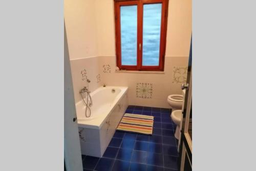 uma casa de banho com uma banheira, um WC e uma janela. em Villa Le Bitte - Porto Santo Stefano em Porto Santo Stefano