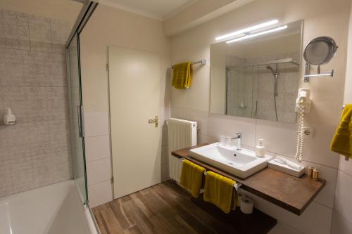 a bathroom with a sink and a shower at Landhotel Gillenfelder Hof in Gillenfeld