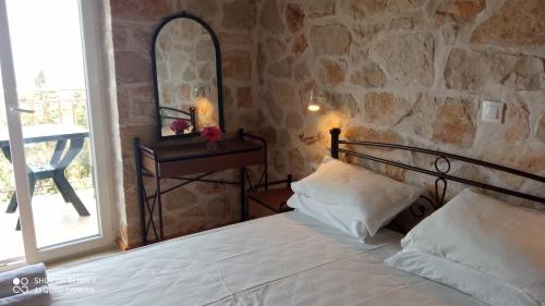 1 dormitorio con cama y pared de piedra en Climati Studios, en Skinária