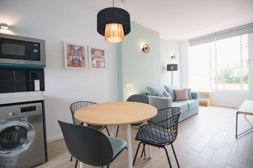 ein Wohnzimmer mit einem Tisch, Stühlen und einem Sofa in der Unterkunft Apartamentos Líbere Valencia Abastos in Valencia