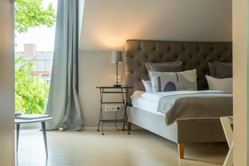 a bedroom with a large bed with a large window at Ko´Ono Hotel in Konstanz