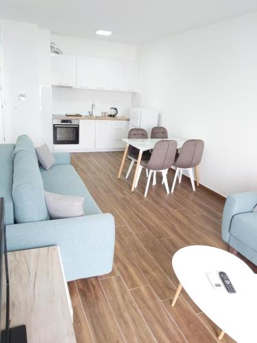 a living room with a blue couch and a table at Apartmani Aida in Dobra Voda