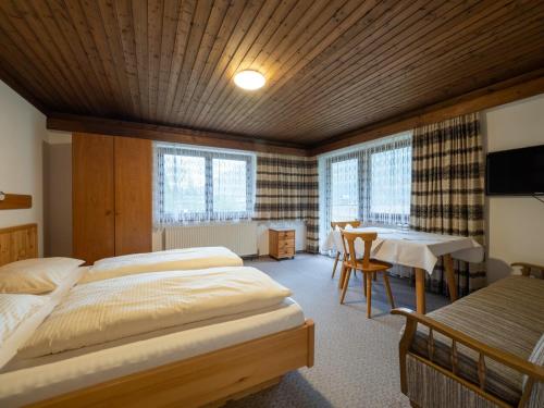1 dormitorio con 2 camas, mesa y comedor en Brandtnerhof Betriebe en Waidring