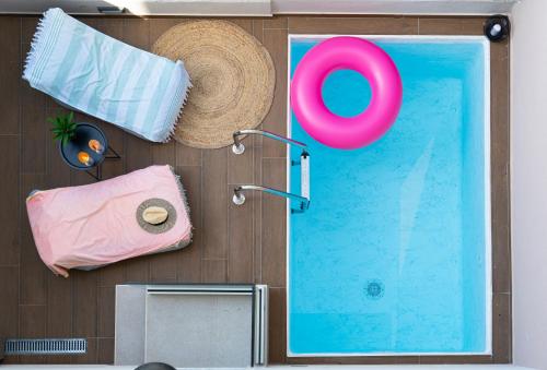 a swimming pool with a straw hat next to a towel and a swimming pool at Aelia Seaside Luxury Suites in Nea Karvali