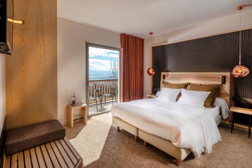 a bedroom with a large bed and a large window at Atmospheres in Le Bourget-du-Lac