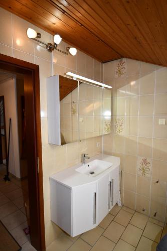 a bathroom with a white sink and a mirror at Gästehaus Steuer in Bruttig-Fankel