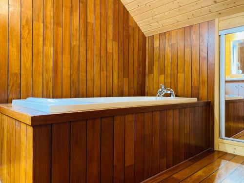 ジェラールメにあるChalet Brimbelleの木製の壁のバスルーム(バスタブ付)