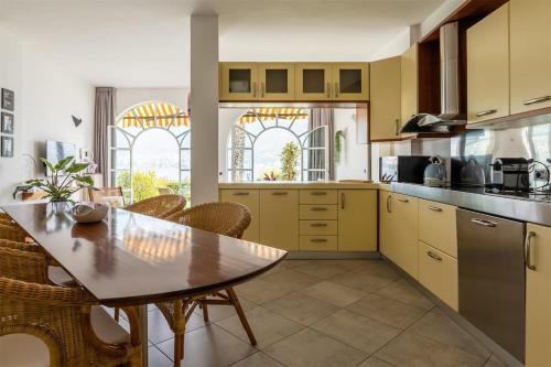 a kitchen with yellow cabinets and a table and chairs at Terrace on the Lake in Oliveto Lario