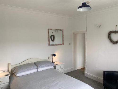 a bedroom with a bed and a table and a mirror at The Sandhaven in Swanage