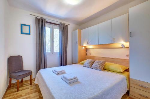 a small bedroom with a bed and a chair at SVEN in Veli Lošinj
