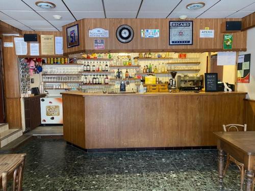 un bar dans un restaurant avec un comptoir et des tables dans l'établissement Hôtel Restaurant de la poste, à Saint-Colomban-des-Villards