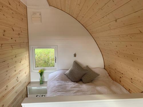 Glastonbury Glamping في ويلْزْ: غرفة نوم صغيرة بها سرير ونافذة