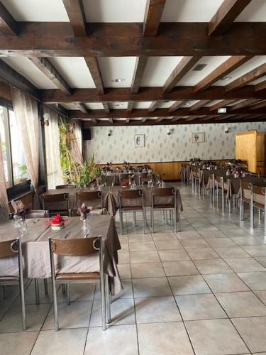 un restaurante con mesas y sillas en una habitación en Hôtel Restaurant de la poste, en Saint-Colomban-des-Villards