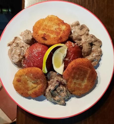 a plate of food with meat and vegetables on a table at Noclegi Sylana in Kobyłka
