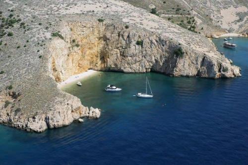 a group of boats in the water next to a cliff at Apartmani Braut in Kornić