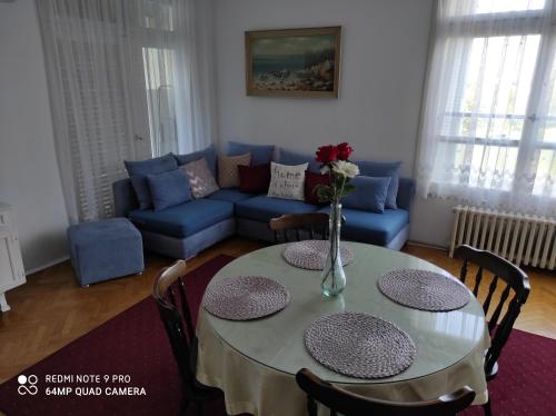 a living room with a table and a blue couch at Apartment Iris Split in Split