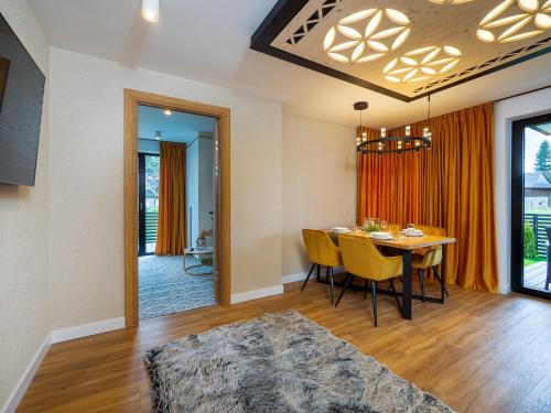 a dining room and living room with a table and chairs at Aparthotel Góralski Spa 2 in Białka Tatrzanska