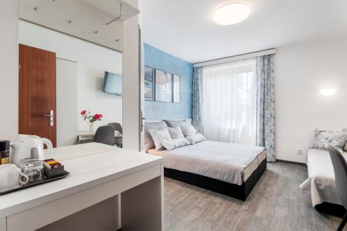 a hotel room with a bed and a kitchen and a room at A.V.E. Pension Kliská in Prague
