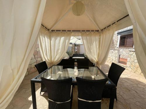 a glass dining table and chairs in a tent at Villa Lucia in Lampedusa