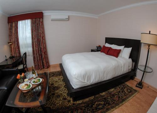 a bedroom with a bed and a couch and a table at Norwalk Inn & Conference Center in Norwalk